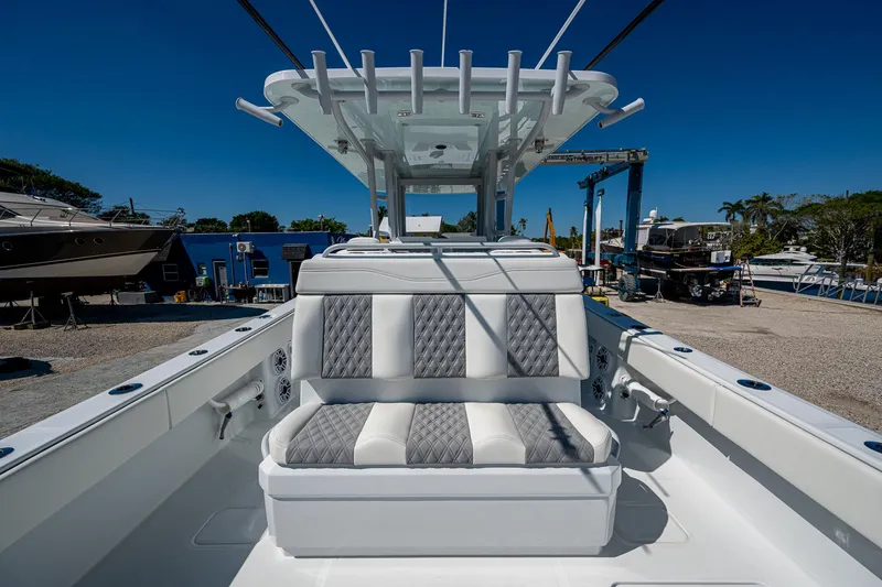 Slide: The Image of 2025 Invincible 33 Catamaran with sleek seating and modern design in a marina setting. - 17