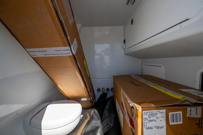 Slide: The Image of Interior of 2025 Invincible 33 Catamaran with storage boxes and a compact toilet. - 22
