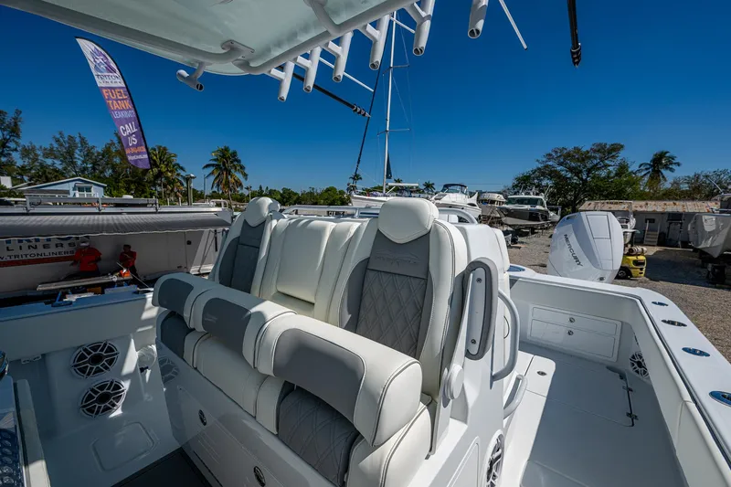 Slide: The Image of 2025 Invincible 33 Catamaran with luxurious seating, docked under clear blue skies. - 23