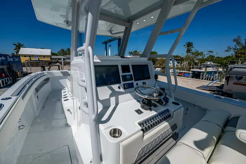Slide: The Image of 2025 Invincible 33 Catamaran cockpit with modern controls and seating, docked under clear skies. - 25