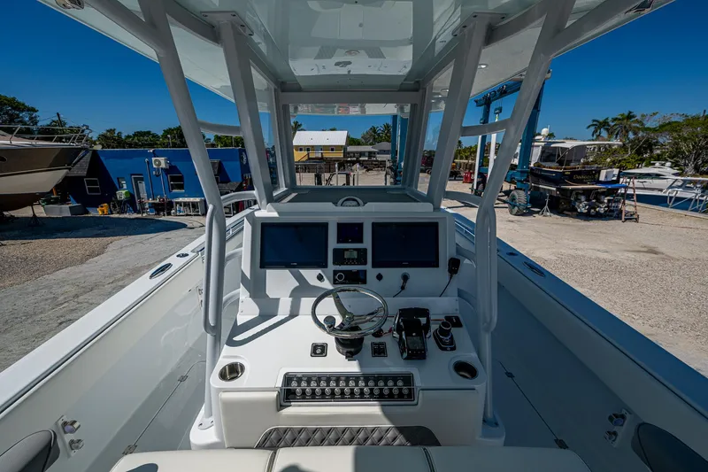 Slide: The Image of 2025 Invincible 33 Catamaran cockpit with modern controls and dual screens, docked at a marina. - 26