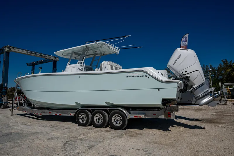 Slide: The Image of 2025 Invincible 33 Catamaran on trailer, side view, clear sky background. - 28