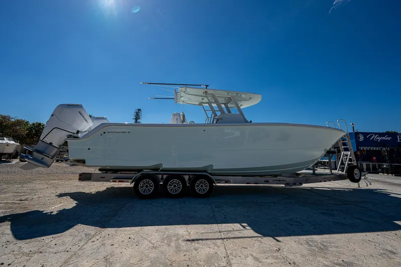 Slide: The Image of 2025 Invincible 33 Catamaran on trailer under clear blue sky. - 31