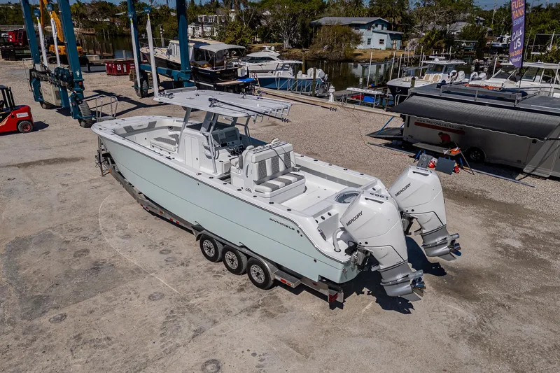 Slide: The Image of 2025 Invincible 33 Catamaran on trailer, dockside, with twin outboard engines. - 36