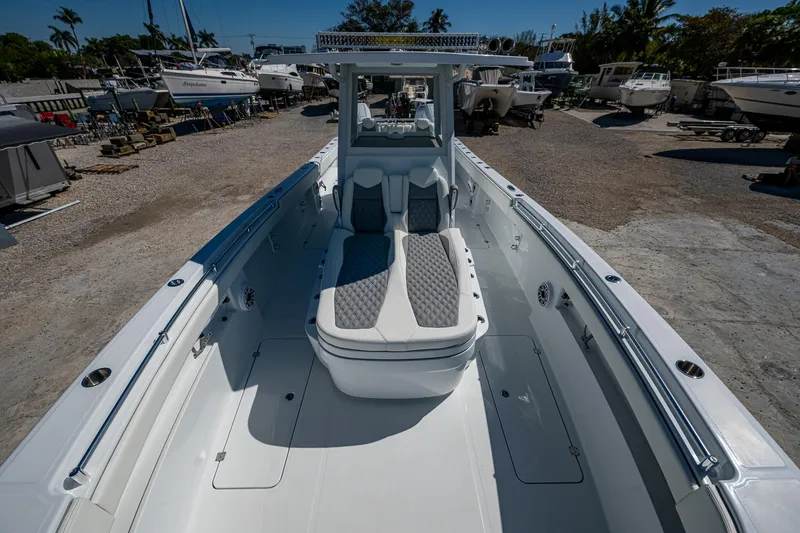 Slide: The Image of 2025 Invincible 33 Catamaran with spacious deck and seating, docked in a marina. - 5