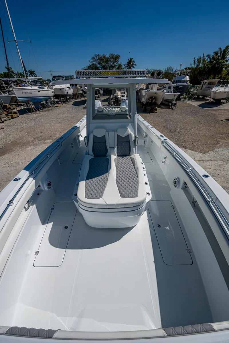 Slide: The Image of 2025 Invincible 33 Catamaran with sleek design and spacious deck in a sunny marina. - 6