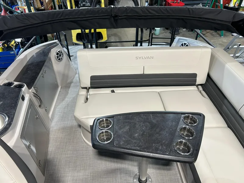 Slide: The Image of 2025 Sylvan G5 CLZ boat interior with seating and table featuring cup holders. - 12