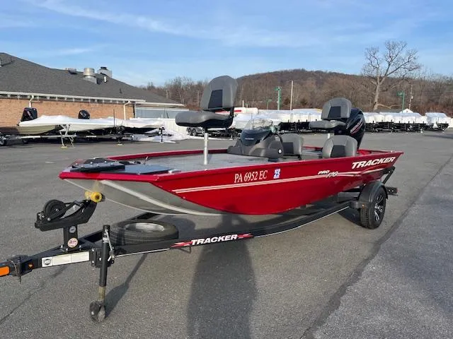 Slide: The Image of 2023 Tracker Pro 170 boat in red, parked on a trailer in a lot. - 3