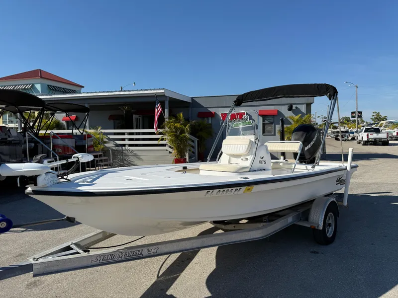 The Image of 2011 Mako 18 LTS Inshore boat on trailer, parked outdoors under clear blue sky. - 1