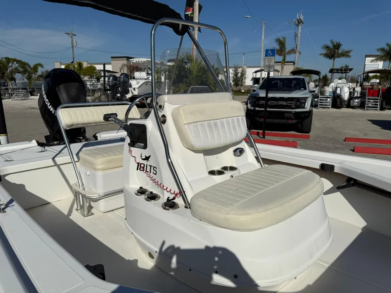 Slide: The Image of 2011 Mako 18 LTS Inshore boat with seating and console, parked outdoors. - 13