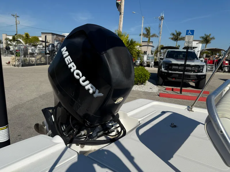 Slide: The Image of 2011 Mako 18 LTS Inshore boat with Mercury outboard motor in a sunny marina. - 14