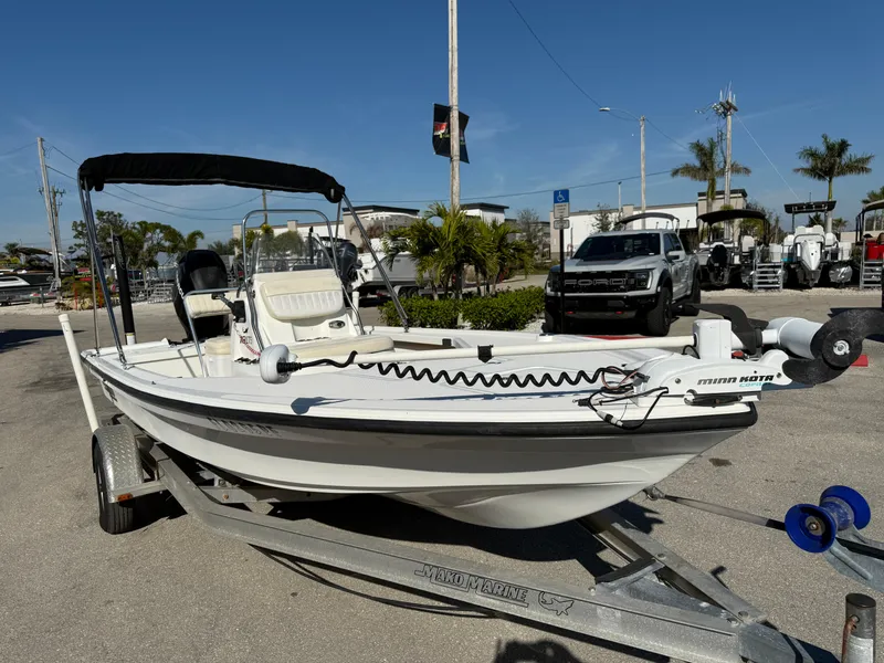 Slide: The Image of 2011 Mako 18 LTS Inshore boat on trailer, parked outdoors under clear blue sky. - 4