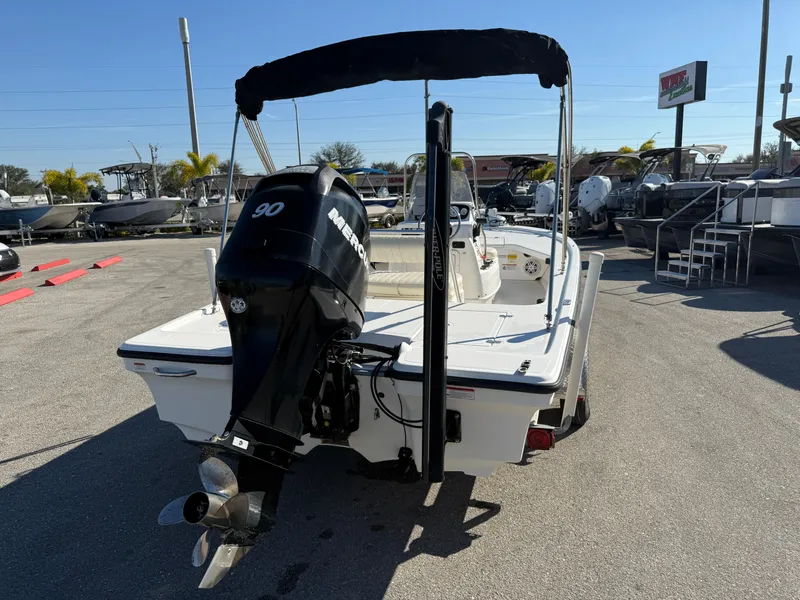 Slide: The Image of 2011 Mako 18 LTS Inshore boat with Mercury 90 outboard motor, parked outdoors. - 6