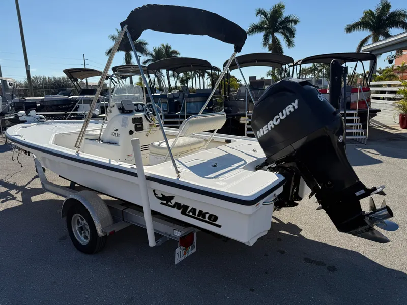Slide: The Image of 2011 Mako 18 LTS Inshore boat with Mercury engine on trailer, parked outdoors. - 8