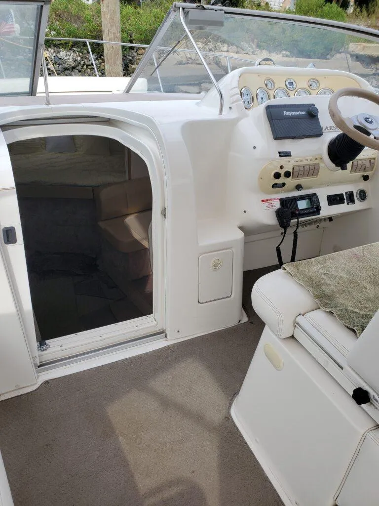 Slide: The Image of 2000 Larson 330 CABRIO boat interior with steering console and cabin entrance. - 11