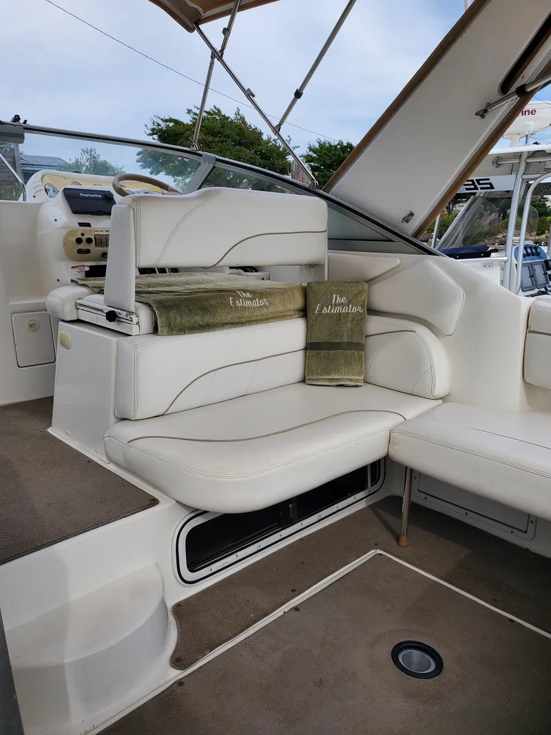 Slide: The Image of 2000 Larson 330 CABRIO boat interior with white seating and green towels. - 13
