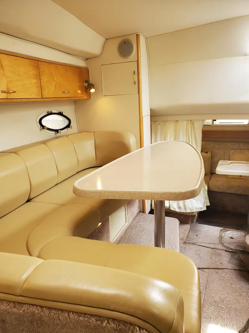 Slide: The Image of Interior of a 2000 Larson 330 Cabrio boat with beige seating and table. - 19