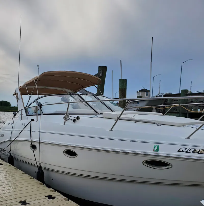 Slide: The Image of 2000 Larson 330 CABRIO boat docked at marina under cloudy sky. - 2