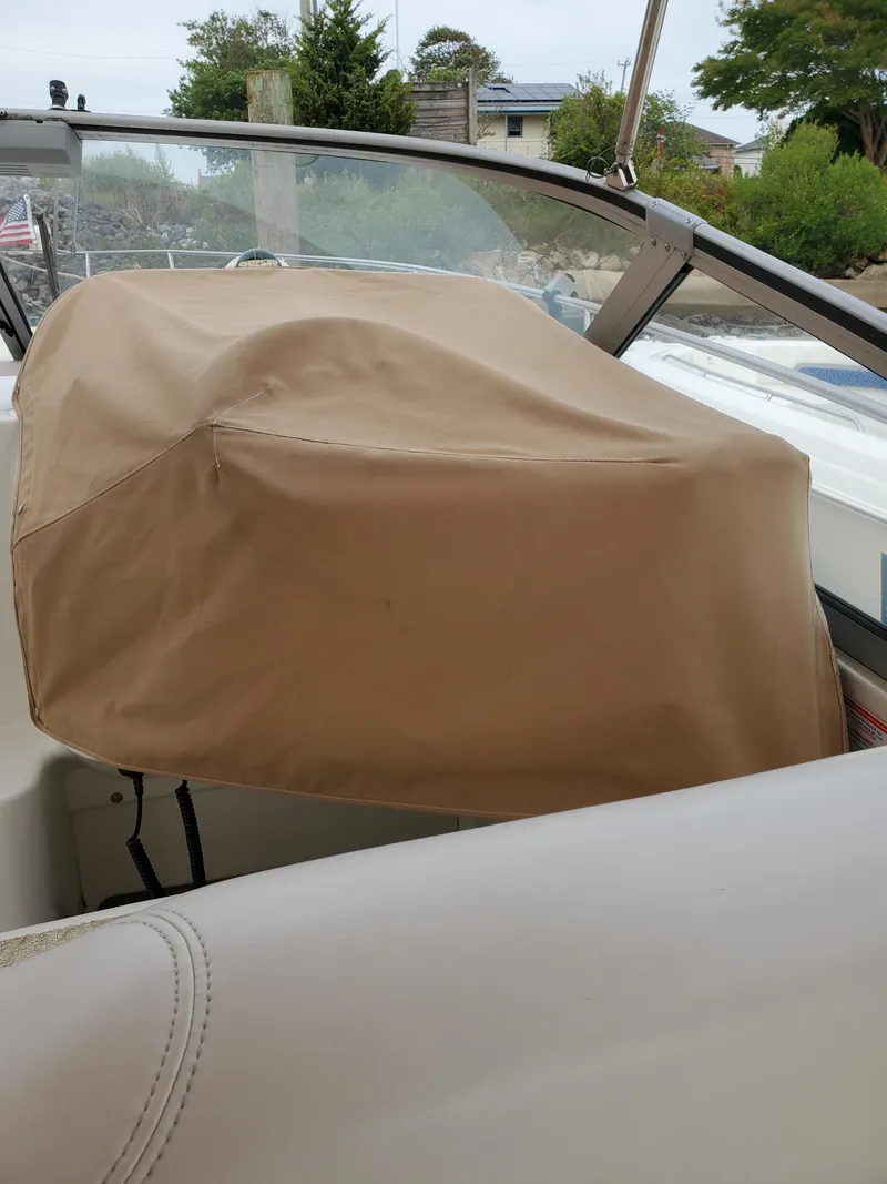 Slide: The Image of Covered helm of a 2000 Larson 330 CABRIO boat, with beige protective cover. - 27