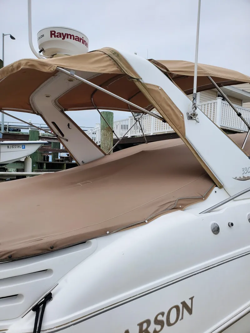 Slide: The Image of 2000 Larson 330 CABRIO boat with tan canopy and Raymarine radar at dock. - 3