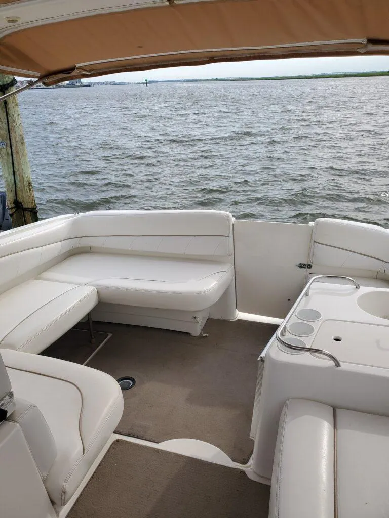 Slide: The Image of Interior of a 2000 Larson 330 CABRIO boat with white seating and water view. - 9