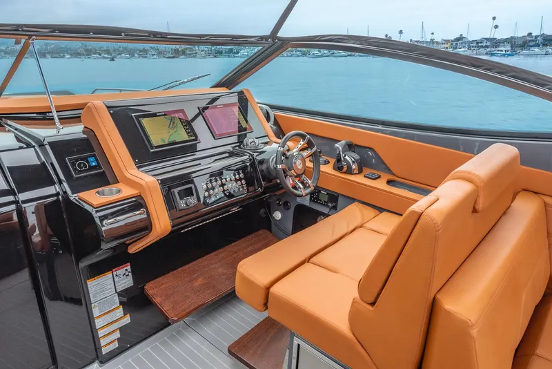Slide: The Image of 2022 Cruisers Yachts 38 GLS helm with orange seating and modern dashboard. - 12