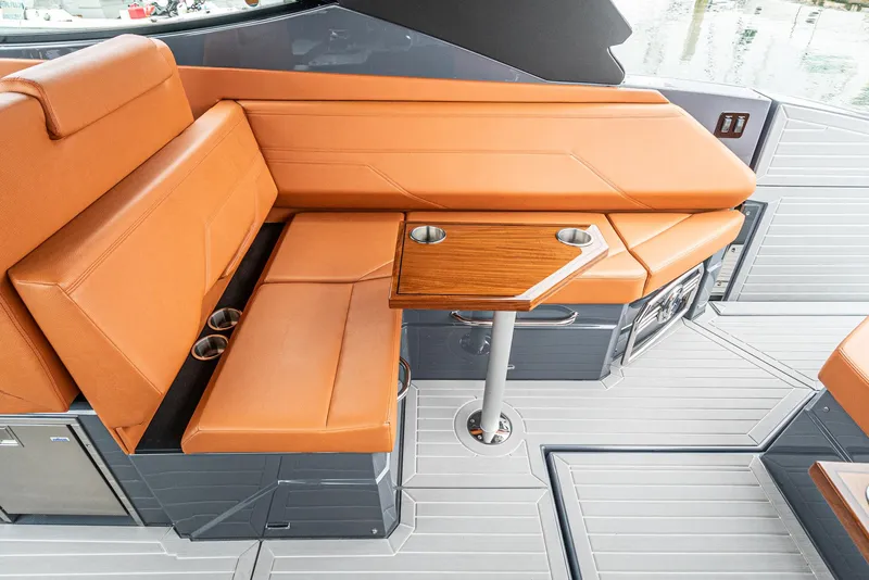 Slide: The Image of 2022 Cruisers Yachts 38 GLS interior with orange seating and wooden table. - 19