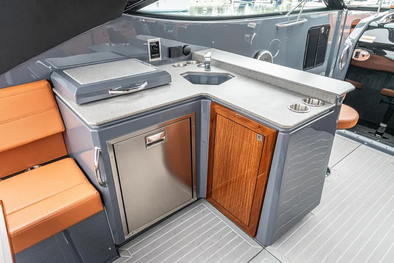 Slide: The Image of 2022 Cruisers Yachts 38 GLS interior with kitchenette, featuring sink, grill, and storage. - 21