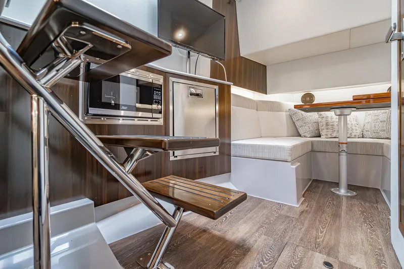 Slide: The Image of Interior of 2022 Cruisers Yachts 38 GLS, featuring modern seating and sleek wooden finishes. - 26