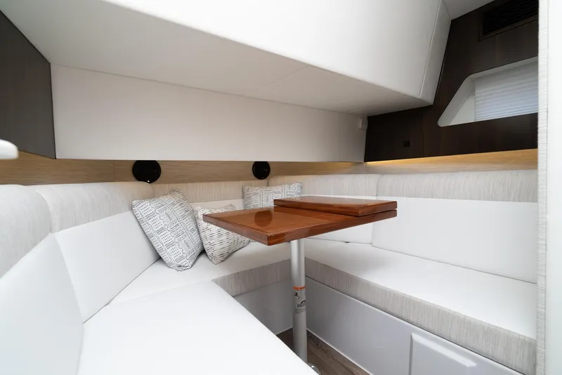 Slide: The Image of 2022 Cruisers Yachts 38 GLS interior with white seating and wooden table. - 27