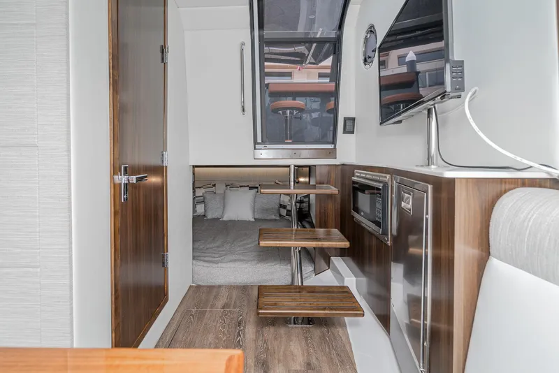 Slide: The Image of Interior of 2022 Cruisers Yachts 38 GLS, featuring modern kitchen and cozy sleeping area. - 29