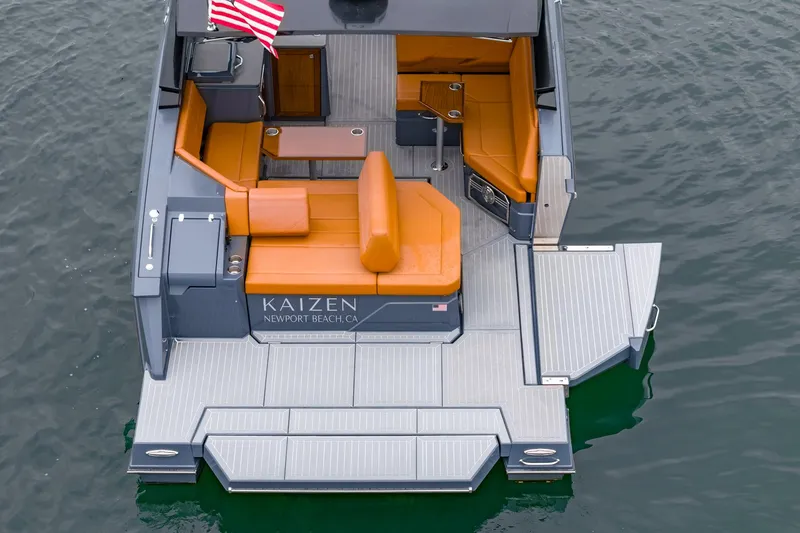 Slide: The Image of 2022 Cruisers Yachts 38 GLS with orange seating, spacious deck, and American flag on water. - 8