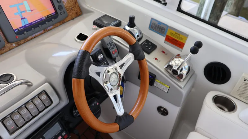 Slide: The Image of 2007 Formula 45 Yacht helm with wooden steering wheel and navigation controls. - 24