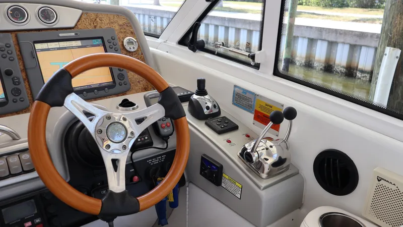 Slide: The Image of 2007 Formula 45 Yacht helm with wooden steering wheel and navigation controls. - 25