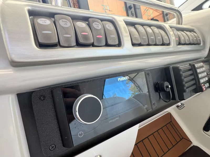 Slide: The Image of Control panel of a 2007 Formula 45 Yacht with various switches and a Fusion audio system. - 30