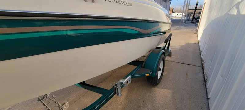 Slide: The Image of 1997 Four Winns 200 Horizon boat with teal and beige wave design on the side. - 24
