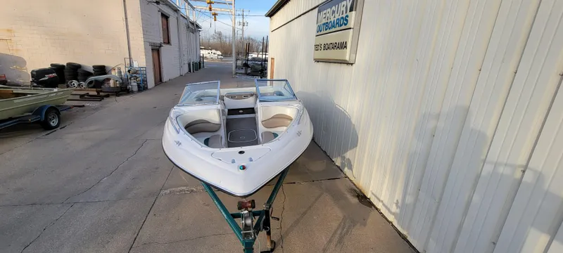 Slide: The Image of 1997 Four Winns 200 Horizon boat on trailer, parked outside a building. - 5