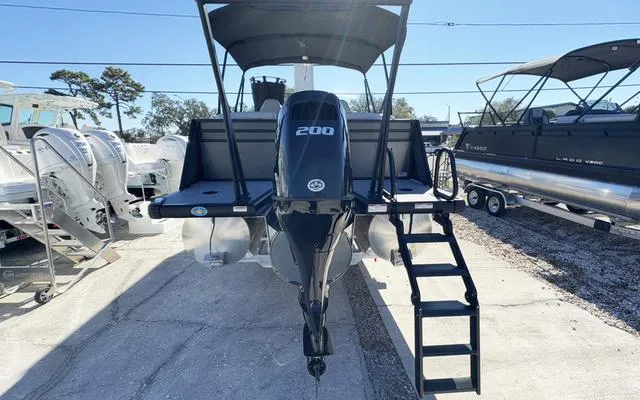 Slide: The Image of Viaggio Lago X22U 2025 pontoon boat with 200 HP engine, docked outdoors. - 7