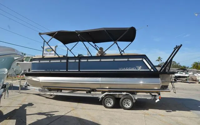 Slide: The Image of 2025 Viaggio Lago X 22 U pontoon boat on trailer, featuring sleek design and canopy. - 5