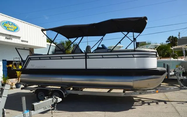 Slide: The Image of 2025 Viaggio LAgo X 22 Q pontoon boat on trailer, parked outside dealership. - 11