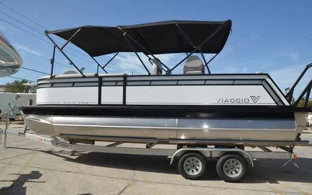 Slide: The Image of 2025 Viaggio Lago X 22 Q pontoon boat on trailer, featuring sleek design and canopy. - 5