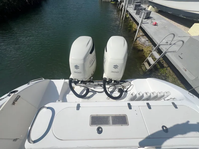 Slide: The Image of 2004 Century 2900 Center Console boat with twin Suzuki outboard engines docked by the water. - 12