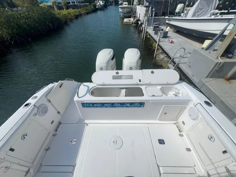 Slide: The Image of 2004 Century 2900 Center Console boat with dual engines docked by a canal. - 13