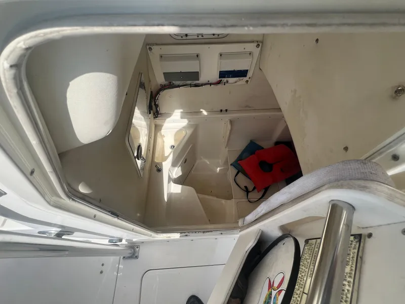 Slide: The Image of Interior cabin of 2004 Century 2900 Center Console boat, showing storage and seating area. - 15