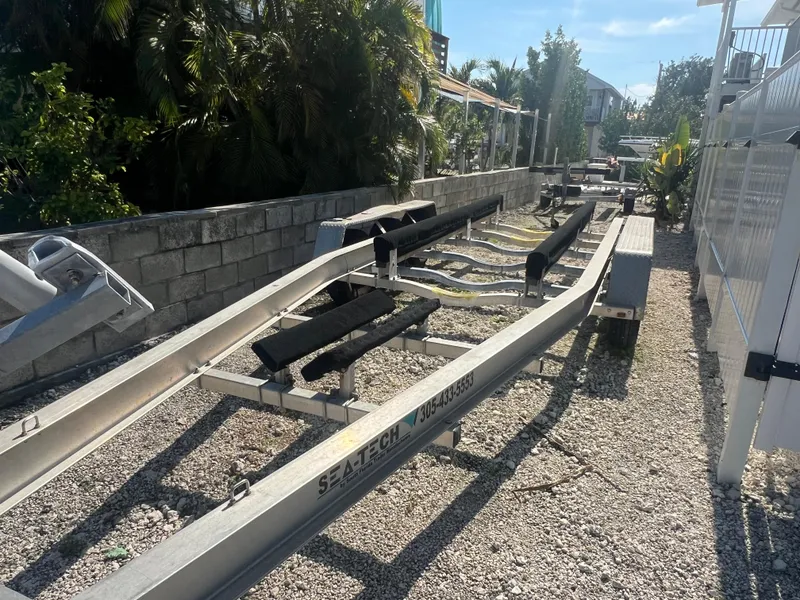 Slide: The Image of Boat trailer on gravel, surrounded by greenery and buildings. - 17