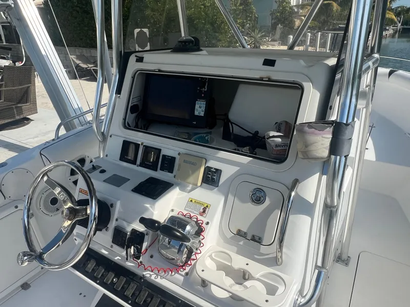 Slide: The Image of 2004 Century 2900 Center Console boat dashboard with steering wheel and navigation equipment. - 2