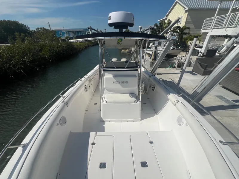 Slide: The Image of 2004 Century 2900 Center Console boat docked by a canal, featuring spacious deck and modern design. - 4