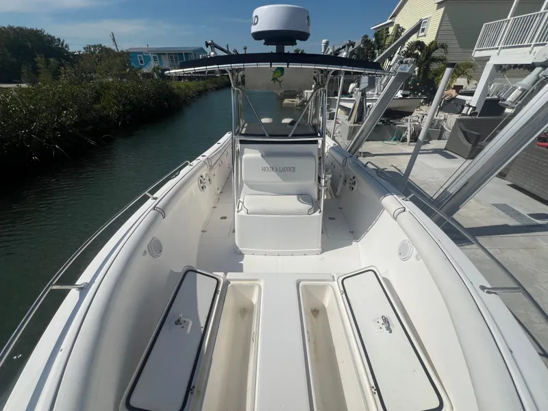 Slide: The Image of 2004 Century 2900 Center Console boat docked by a canal, featuring spacious seating and storage. - 5