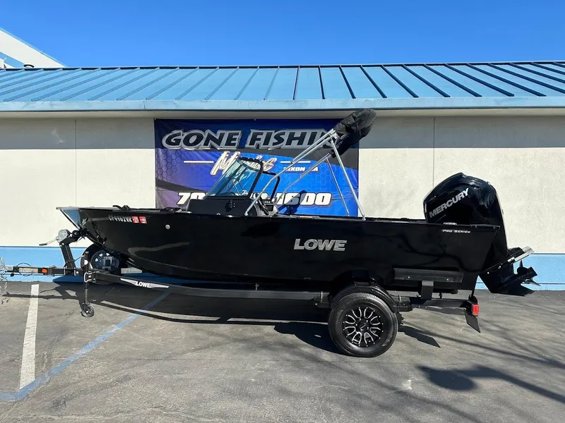 Slide: The Image of 2019 Lowe FM 165 Pro WT fishing boat with Mercury engine, parked outdoors. - 1