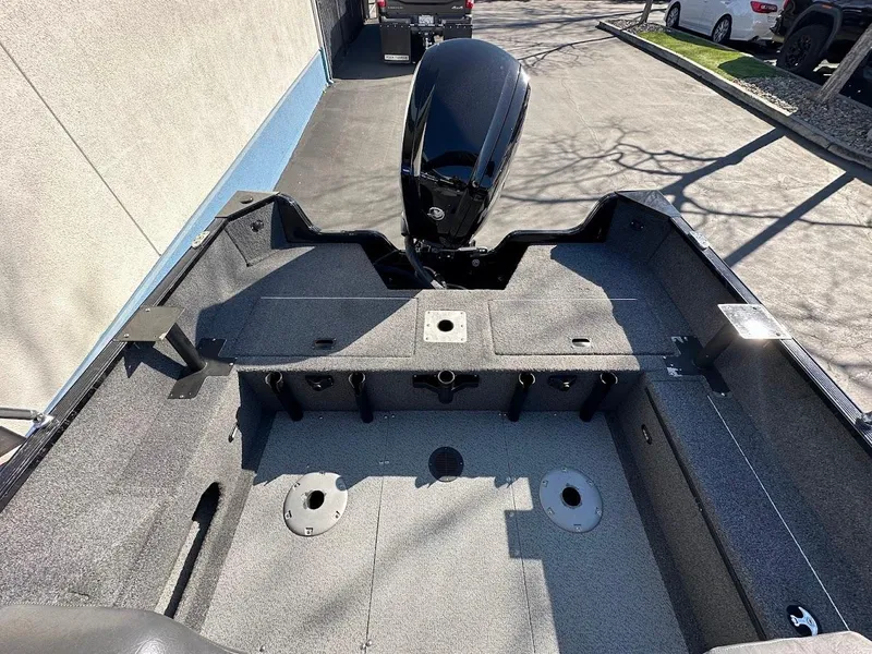 Slide: The Image of 2019 Lowe FM 165 Pro WT boat interior with motor, parked on pavement. - 16